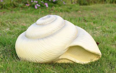 草地上擺放的圓形的玻璃鋼仿真海螺雕塑