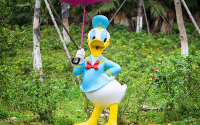 花園一只撐傘的玻璃鋼唐老鴨雕塑