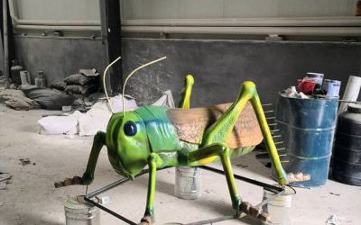 公園里擺放的棕色翅膀的玻璃鋼彩繪蚱蜢雕塑